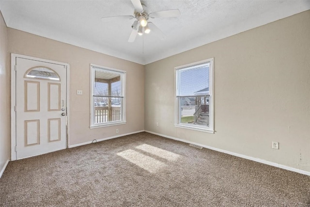 spare room featuring ceiling fan and carpet floors