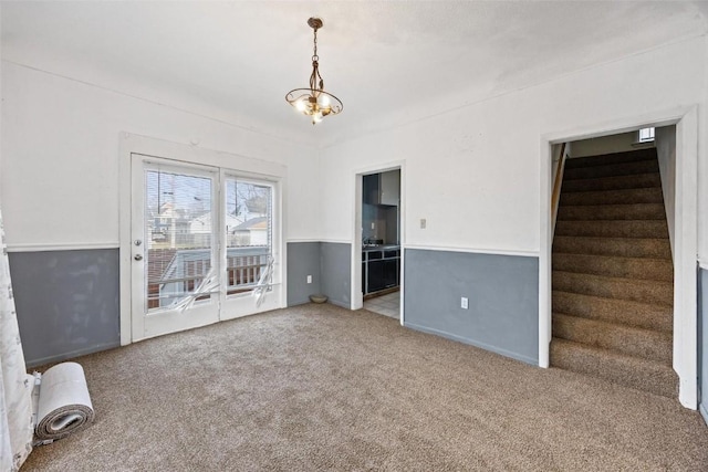 empty room with carpet and a chandelier