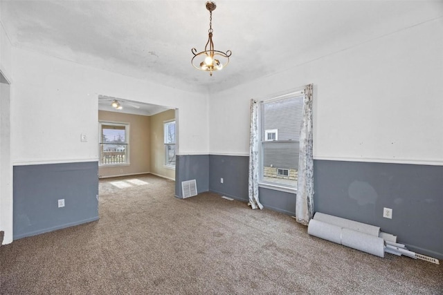 spare room with ceiling fan with notable chandelier and carpet floors