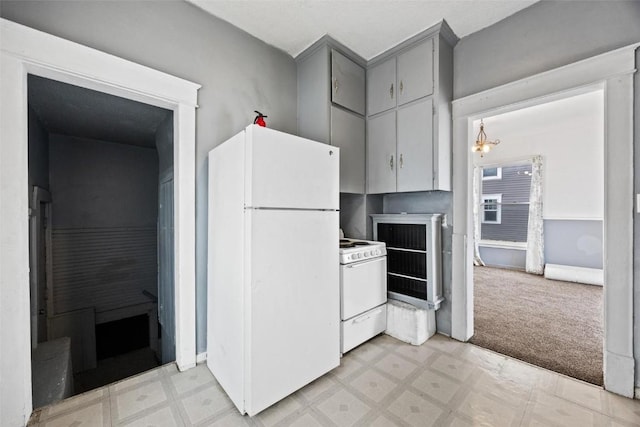 kitchen featuring light carpet, white appliances, gray cabinetry, and a notable chandelier