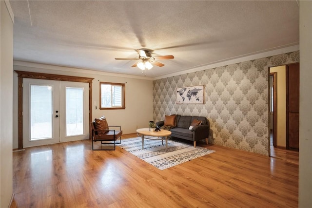 living room with french doors, hardwood / wood-style flooring, ceiling fan, and ornamental molding