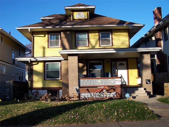 view of front facade with covered porch and a front lawn