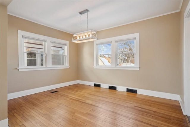 unfurnished dining area featuring ornamental molding, wood finished floors, and visible vents