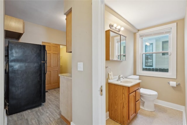 bathroom with vanity, toilet, and baseboards