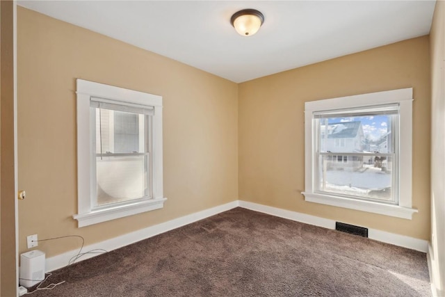 carpeted empty room featuring visible vents and baseboards