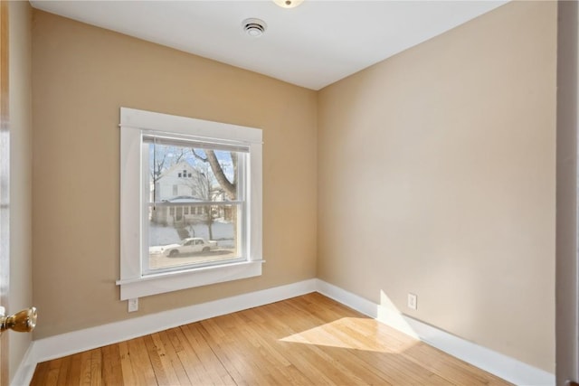 unfurnished room with baseboards and wood finished floors