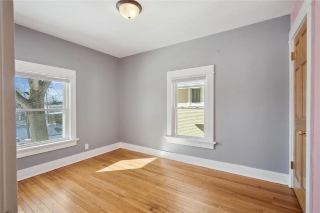 spare room featuring wood finished floors and baseboards