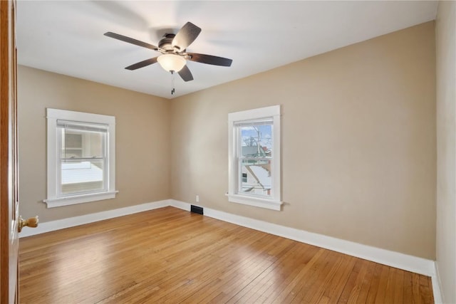 unfurnished room featuring visible vents, ceiling fan, light wood finished floors, and baseboards