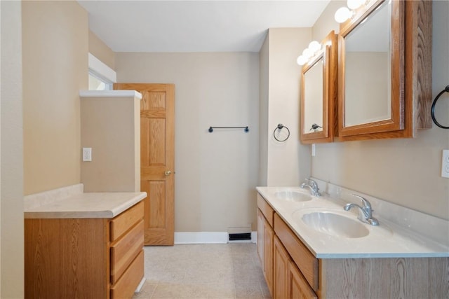 bathroom featuring double vanity, a sink, visible vents, and baseboards