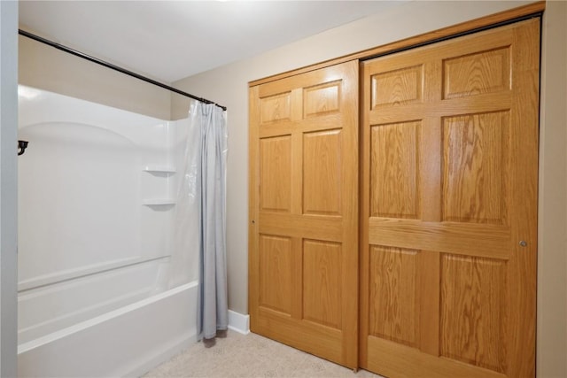 bathroom featuring shower / bath combo with shower curtain and baseboards