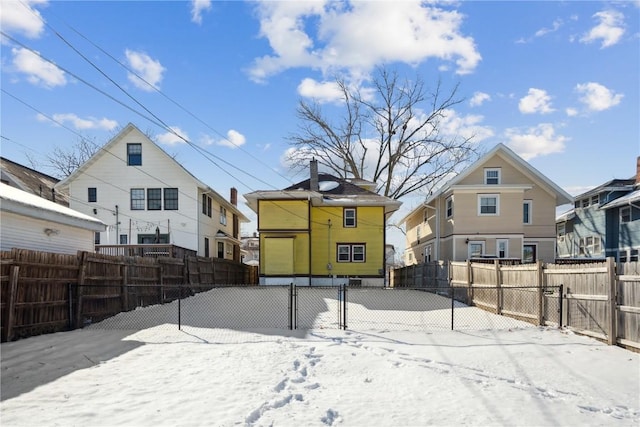 yard layered in snow with fence and a residential view