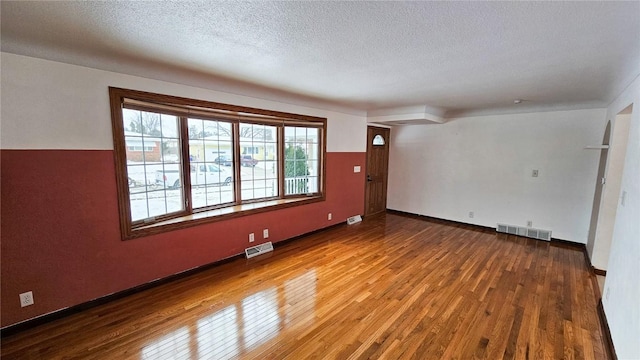 spare room with wood-type flooring and a textured ceiling