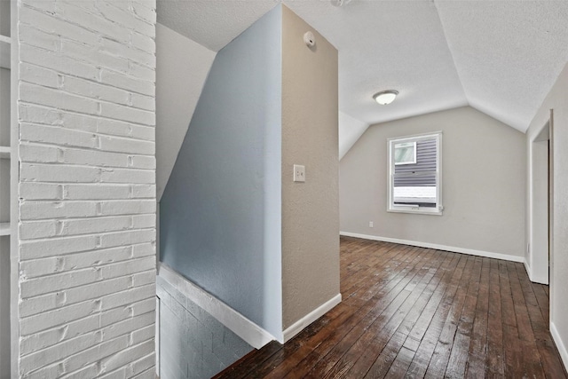 bonus room with hardwood / wood-style floors, a textured ceiling, and lofted ceiling