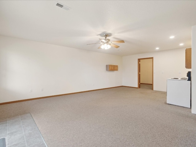 interior space with washer / clothes dryer, light carpet, and ceiling fan