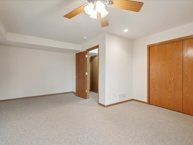 unfurnished bedroom featuring ceiling fan, light carpet, and a closet