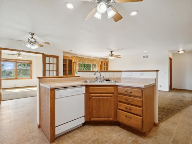 kitchen with white dishwasher, sink, a wealth of natural light, and light carpet