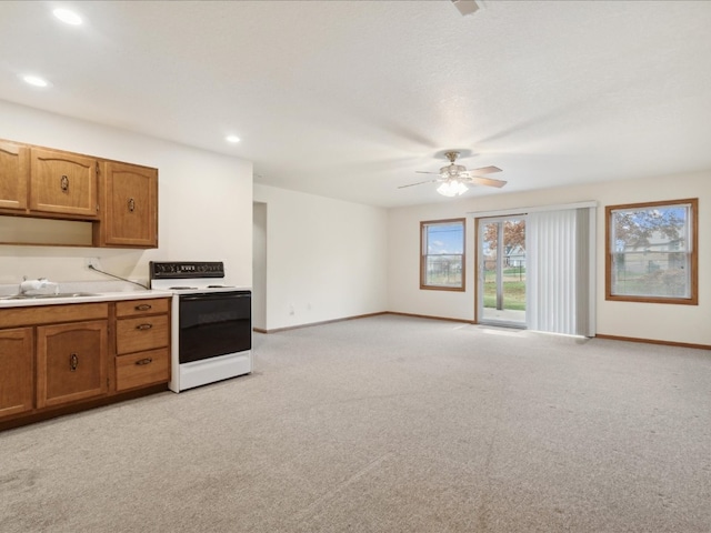 kitchen with light colored carpet, white range with electric stovetop, ceiling fan, and sink