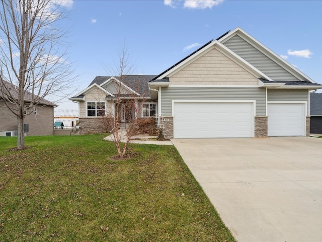 craftsman inspired home featuring a garage and a front lawn