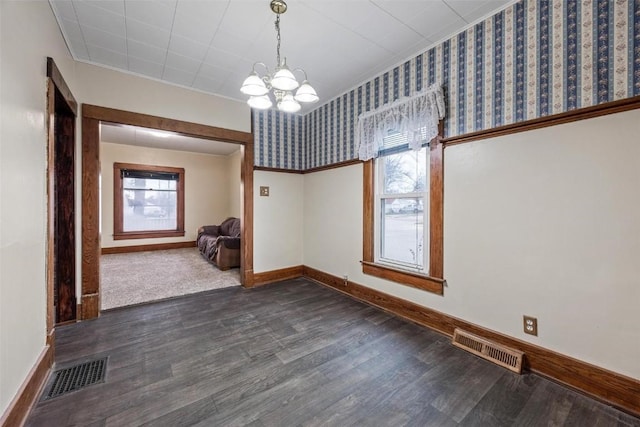 unfurnished dining area with dark hardwood / wood-style flooring and an inviting chandelier