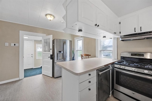 kitchen featuring white cabinets, appliances with stainless steel finishes, and a wealth of natural light