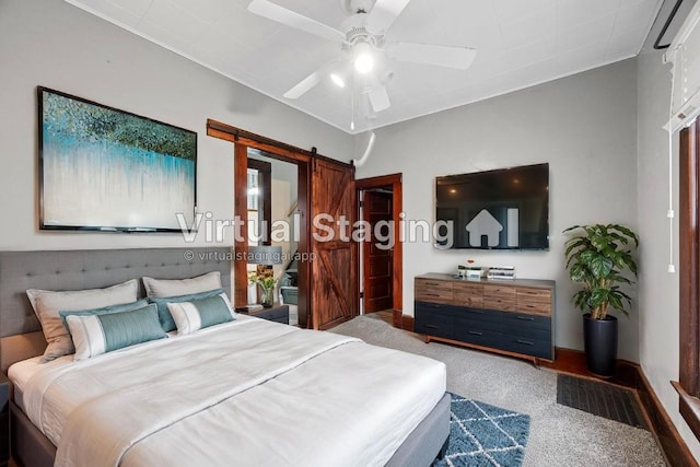 carpeted bedroom with ceiling fan and a barn door