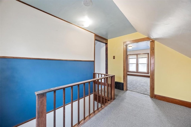 hall featuring carpet flooring and lofted ceiling