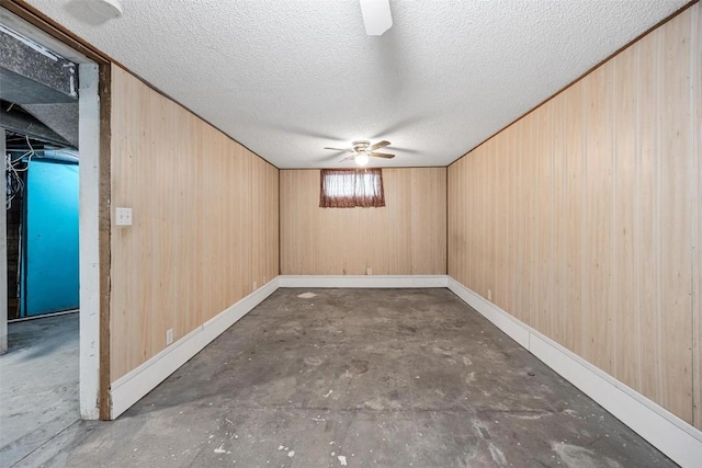 basement with wood walls and a textured ceiling