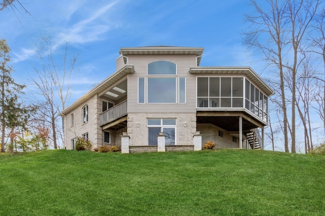 rear view of house featuring a sunroom and a yard