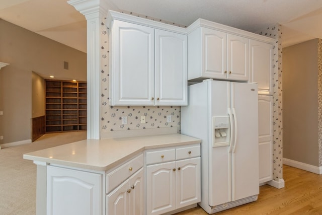 kitchen featuring kitchen peninsula, white fridge with ice dispenser, white cabinets, and light hardwood / wood-style floors