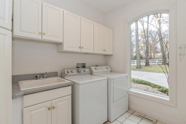 laundry area featuring cabinets, sink, and washing machine and clothes dryer