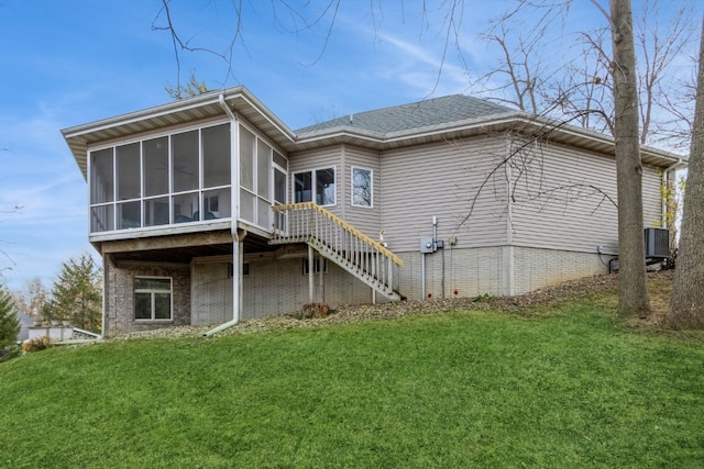 back of property with a yard and a sunroom