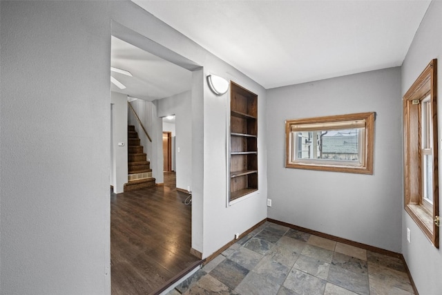 foyer entrance featuring ceiling fan and dark wood-type flooring