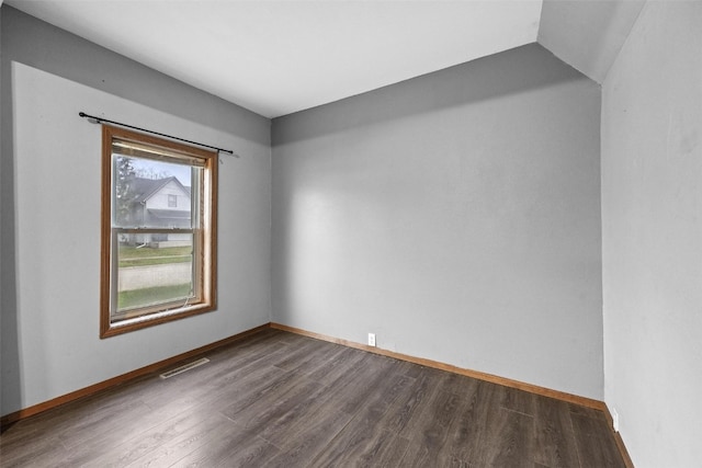 unfurnished room with dark hardwood / wood-style flooring and vaulted ceiling