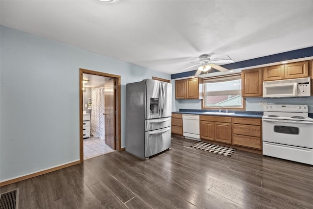 kitchen with dark hardwood / wood-style flooring, white appliances, ceiling fan, and sink