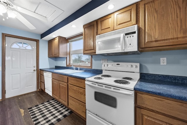 kitchen featuring ceiling fan, sink, white appliances, and dark wood-type flooring