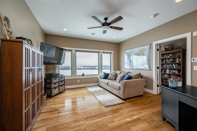 living room with ceiling fan and light wood-type flooring