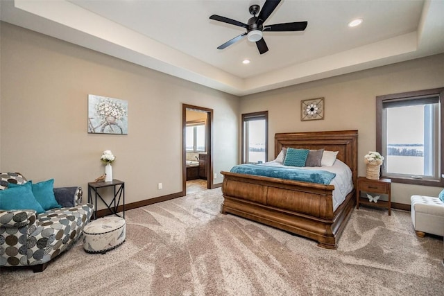 carpeted bedroom featuring ceiling fan, connected bathroom, and a raised ceiling