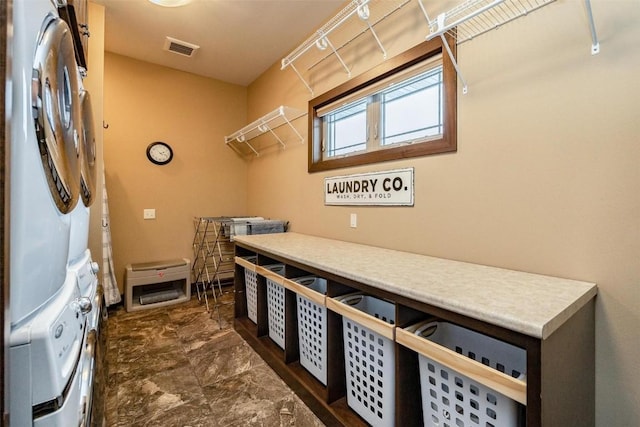 washroom featuring stacked washer / dryer