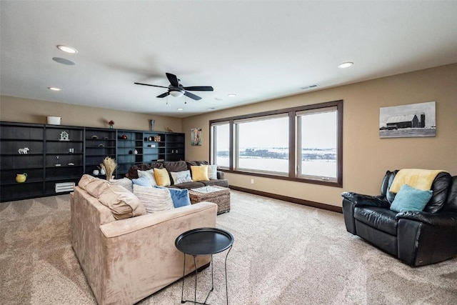 living room with light carpet, ceiling fan, and a water view