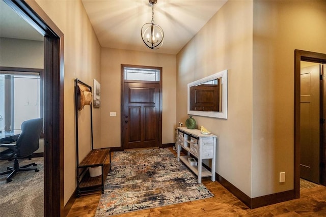 foyer entrance featuring dark hardwood / wood-style floors and a notable chandelier