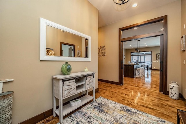 hallway with light hardwood / wood-style floors