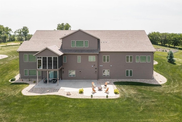 rear view of property with a fire pit, a yard, and a patio area