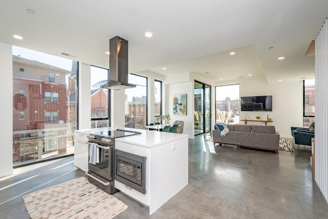 kitchen with island range hood, black microwave, electric stove, white cabinets, and a center island