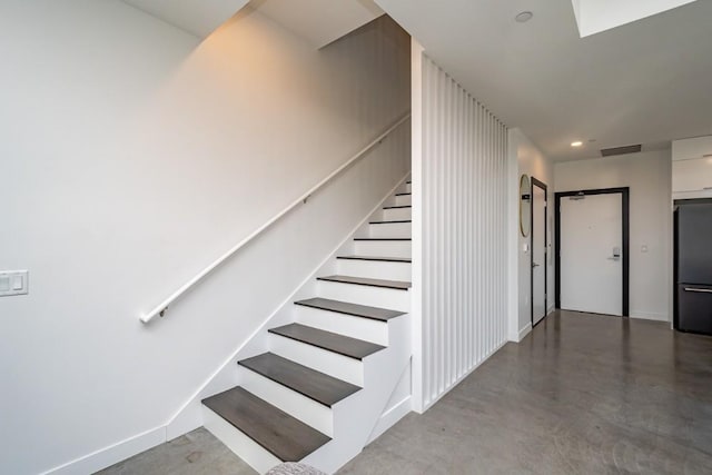 staircase featuring concrete floors