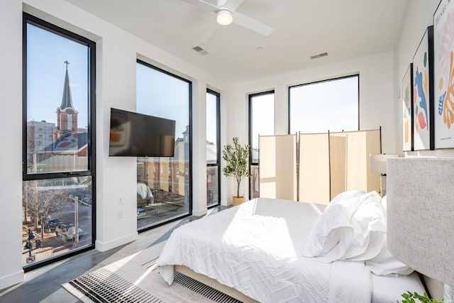 bedroom featuring access to outside, ceiling fan, and concrete floors