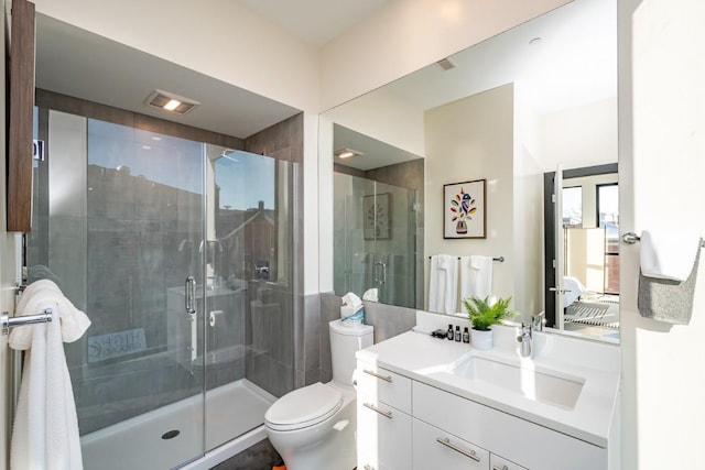 bathroom with vanity, an enclosed shower, and toilet