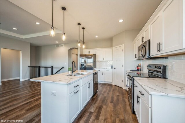 kitchen featuring sink, a center island with sink, appliances with stainless steel finishes, pendant lighting, and white cabinets