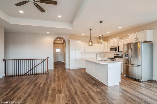 kitchen featuring dark hardwood / wood-style flooring, stainless steel appliances, hanging light fixtures, and sink