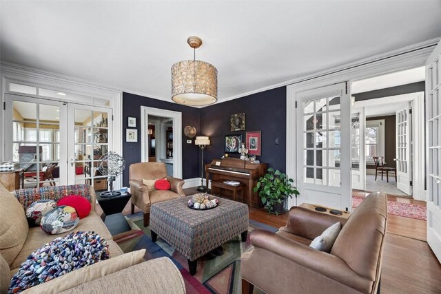 living room featuring crown molding, french doors, and hardwood / wood-style flooring