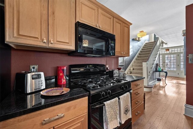 kitchen with light hardwood / wood-style flooring and black appliances